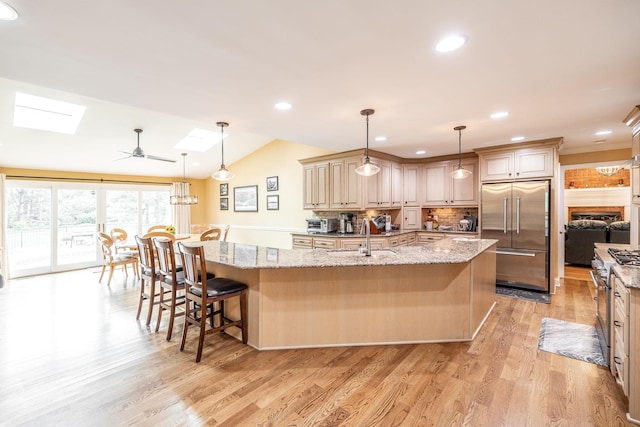 1234 Windsor Dr, Gallatin, TN 37066 - kitchen featuring high end appliances, a sink, a skylight, a breakfast bar, and tasteful backsplash