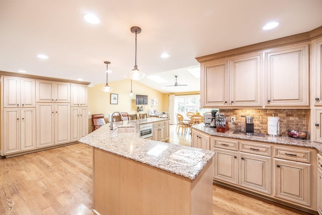 1234 Windsor Dr, Gallatin, TN 37066 - kitchen featuring a sink, backsplash, light wood-style flooring, a large island with sink, and light stone counters
