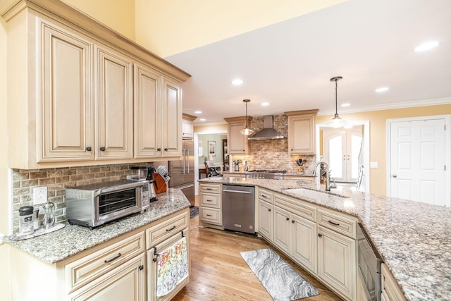 1234 Windsor Dr, Gallatin, TN 37066 - kitchen with a sink, stainless steel appliances, wall chimney range hood, cream cabinetry, and ornamental molding