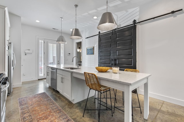 682 James Ave, Nashville, TN 37209 - kitchen featuring a barn door, a sink, baseboards, stainless steel appliances, and white cabinets