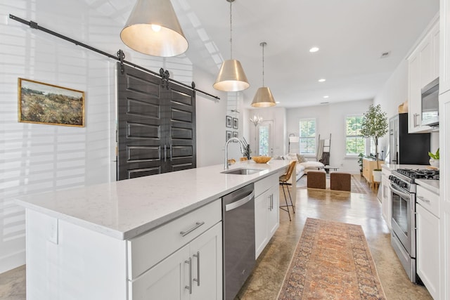 682 James Ave, Nashville, TN 37209 - kitchen with a barn door, appliances with stainless steel finishes, a sink, a center island with sink, and white cabinetry