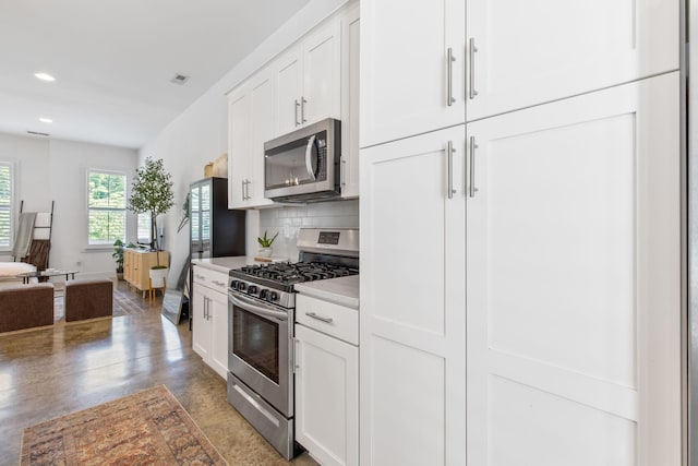 682 James Ave, Nashville, TN 37209 - kitchen with appliances with stainless steel finishes, tasteful backsplash, light countertops, white cabinets, and finished concrete floors