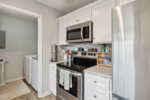 611 Annas Way, Lewisburg, TN 37091 - kitchen with appliances with stainless steel finishes, independent washer and dryer, white cabinetry, light wood-style flooring, and light stone counters