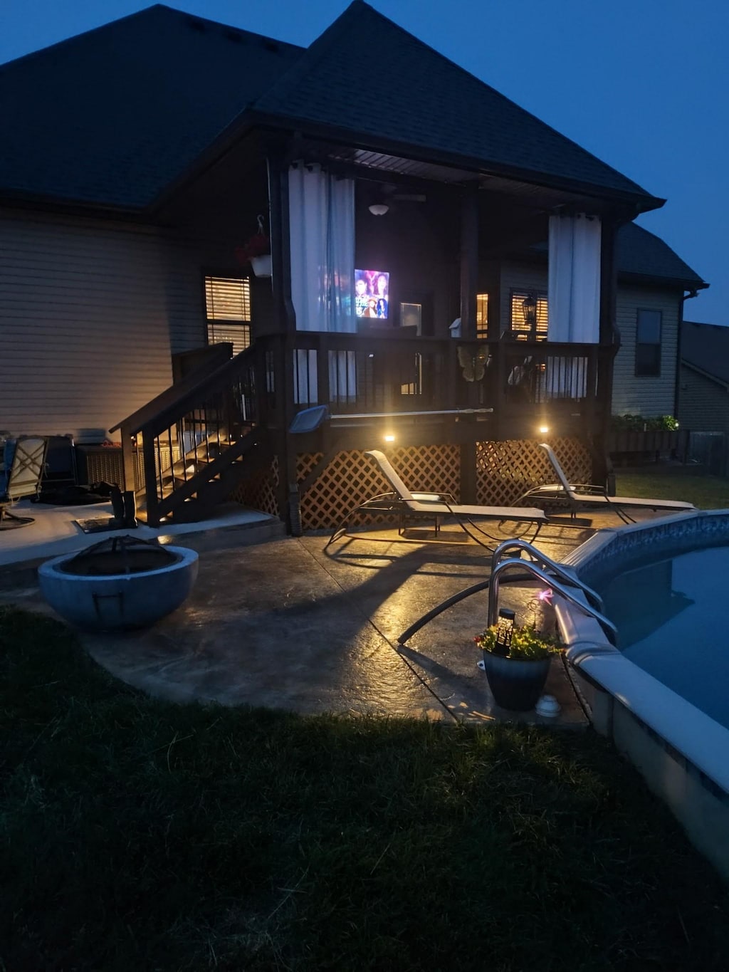 1230 Ridge Meadow Dr, Clarksville, TN 37042 - back of house at night with a shingled roof, a patio, and an outdoor pool