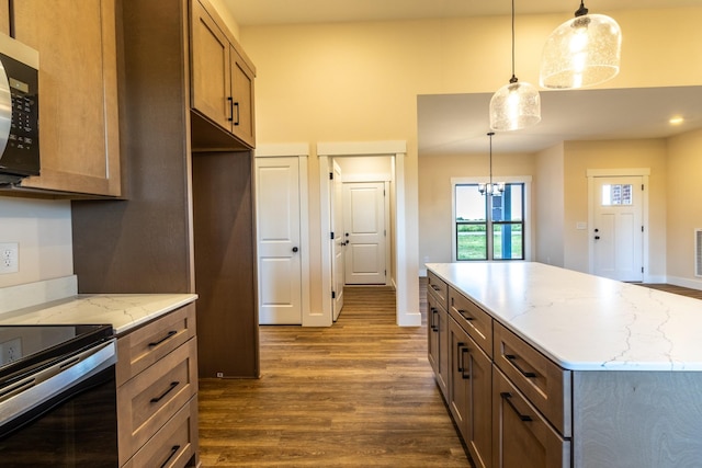 5359 Roy Holman Rd, Springfield, TN 37172 - kitchen with dark wood-style flooring, stainless steel appliances, light stone counters, a towering ceiling, and hanging light fixtures