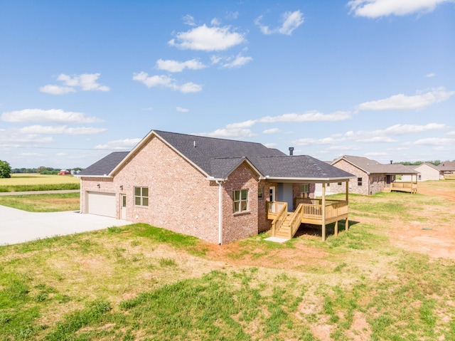 5359 Roy Holman Rd, Springfield, TN 37172 - back of house with driveway, brick siding, a deck, an attached garage, and roof with shingles