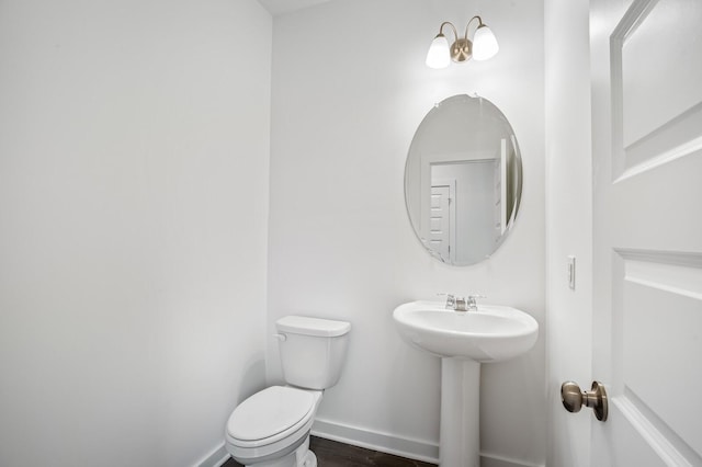 2278 Sutton Dr, White House, TN 37188 - half bathroom featuring toilet, baseboards, a sink, and wood finished floors