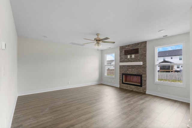 231 Donegal Dr, Clarksville, TN 37042 - unfurnished living room featuring wood finished floors, a ceiling fan, a stone fireplace, and baseboards