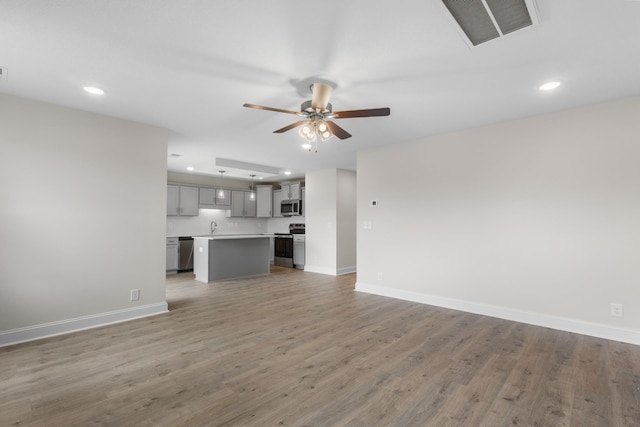 1013 Cherry Acres Dr, Clarksville, TN 37042 - unfurnished living room featuring a sink, recessed lighting, baseboards, ceiling fan, and light wood-type flooring