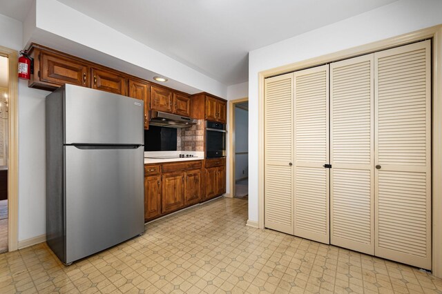 412 Benton Ln, Franklin, TN 37067 - kitchen featuring stainless steel appliances, under cabinet range hood, baseboards, tasteful backsplash, and light countertops
