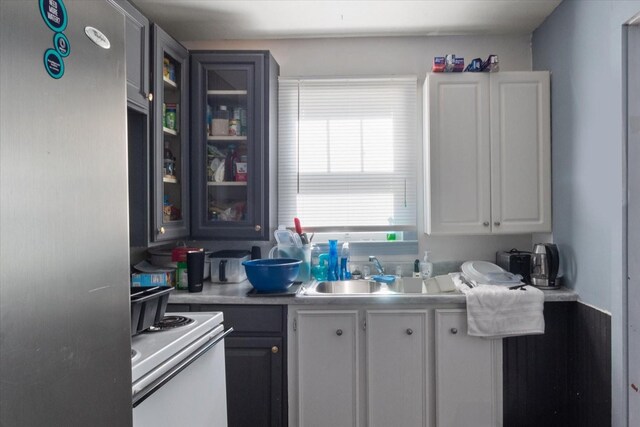 525 Maple St, Lewisburg, TN 37091 - kitchen featuring range, glass insert cabinets, light countertops, white cabinets, and freestanding refrigerator