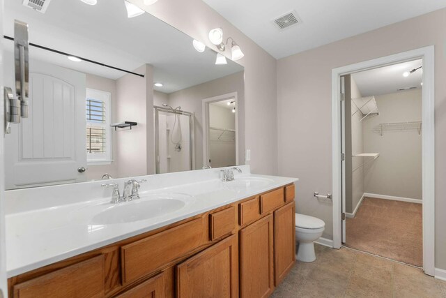 1205 Riverbirch Way, Hermitage, TN 37076 - full bathroom featuring a spacious closet, a stall shower, double vanity, toilet, and baseboards