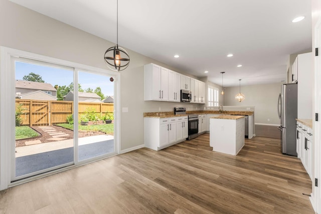 1205 Riverbirch Way, Hermitage, TN 37076 - kitchen featuring appliances with stainless steel finishes, a center island, wood finished floors, baseboards, and a sink