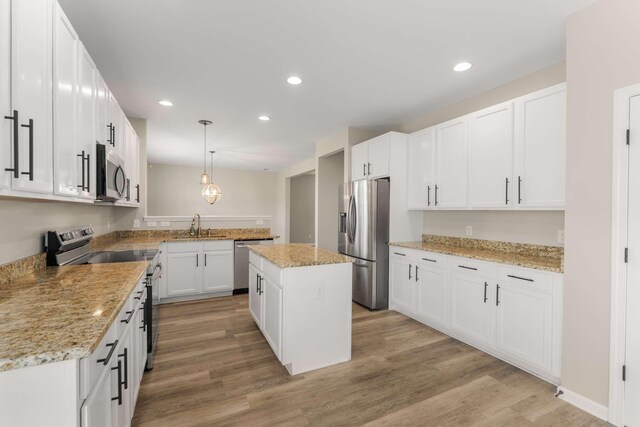 1205 Riverbirch Way, Hermitage, TN 37076 - kitchen featuring appliances with stainless steel finishes, a sink, light wood-style flooring, a center island, and white cabinets