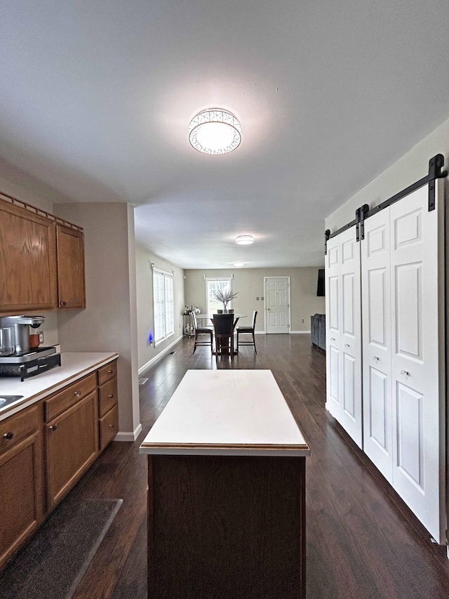 305 Wildwood Dr, Smyrna, TN 37167 - kitchen featuring a barn door, brown cabinets, open floor plan, and dark wood-type flooring