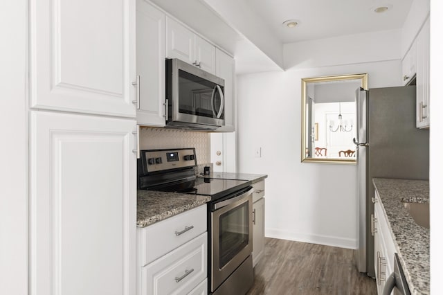 5025 Hillsboro Pike Unit 24K, Nashville, TN 37215 - kitchen with appliances with stainless steel finishes, white cabinets, dark wood-style floors, stone countertops, and baseboards