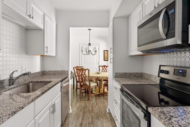 5025 Hillsboro Pike Unit 24K, Nashville, TN 37215 - kitchen featuring appliances with stainless steel finishes, a sink, tasteful backsplash, and white cabinetry