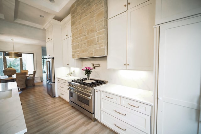 1465 Smith Rd, Lebanon, TN 37087 - kitchen with appliances with stainless steel finishes, light wood finished floors, wall chimney exhaust hood, white cabinets, and hanging light fixtures