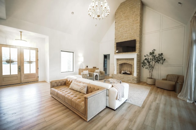 1465 Smith Rd, Lebanon, TN 37087 - living room featuring light wood-style floors, a chandelier, french doors, high vaulted ceiling, and a brick fireplace