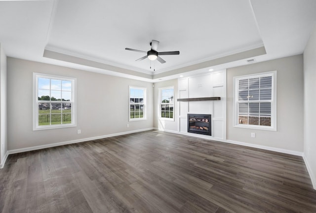 2578 Rafiki Dr, Clarksville, TN 37042 - unfurnished living room featuring a tray ceiling, ceiling fan, dark wood-type flooring, healthy amount of natural light, and ornamental molding