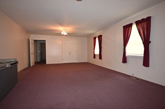 148 W Fourth Ave, Lobelville, TN 37097 - unfurnished living room featuring dark carpet and ceiling fan