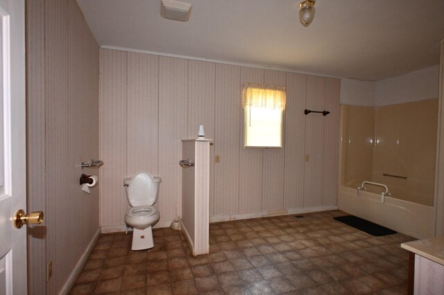 148 W Fourth Ave, Lobelville, TN 37097 - bathroom featuring toilet, baseboards, and bathtub / shower combination