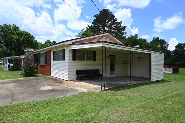 148 W Fourth Ave, Lobelville, TN 37097 - back of house with a yard, driveway, a carport, and a patio area