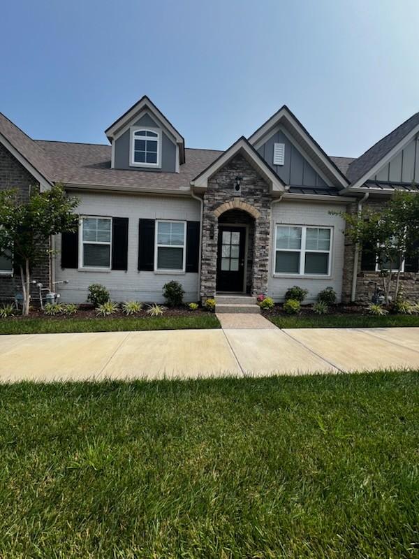 210 Trevor Dr Unit 210, Mount Juliet, TN 37122 - view of front facade featuring board and batten siding, stone siding, and a front lawn