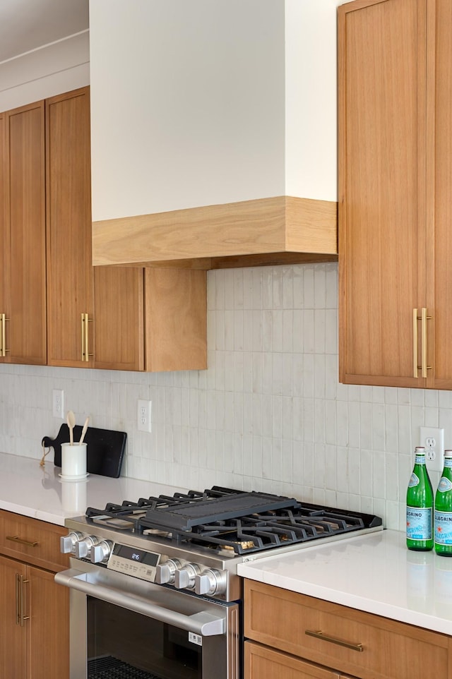 1330 Mcalpine Ave, Nashville, TN 37216 - kitchen with stainless steel range with gas stovetop, brown cabinets, light countertops, and decorative backsplash