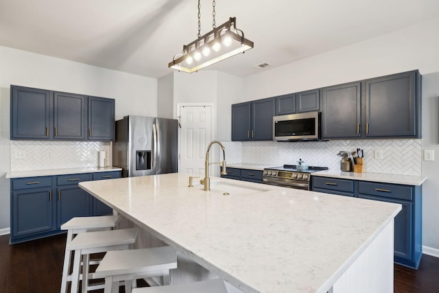 390 Owl Dr, Lebanon, TN 37087 - kitchen featuring appliances with stainless steel finishes, a sink, dark wood-style floors, decorative backsplash, and a kitchen breakfast bar