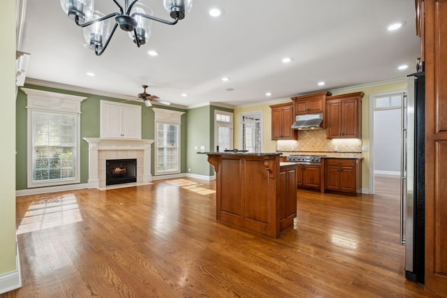 3334 Granite Springs Way, Murfreesboro, TN 37130 - kitchen featuring under cabinet range hood, a kitchen bar, crown molding, backsplash, and baseboards