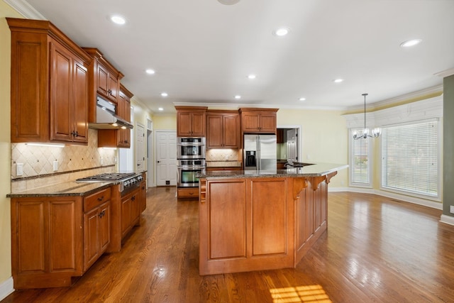 3334 Granite Springs Way, Murfreesboro, TN 37130 - kitchen featuring stainless steel appliances, crown molding, under cabinet range hood, brown cabinets, and dark stone counters