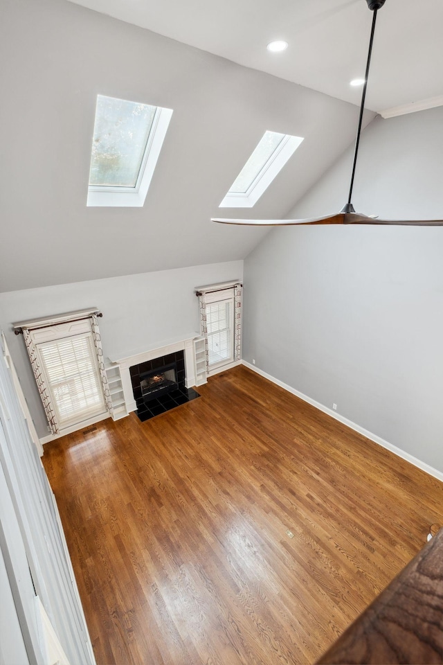3334 Granite Springs Way, Murfreesboro, TN 37130 - unfurnished living room featuring a skylight, a fireplace, vaulted ceiling, wood finished floors, and baseboards