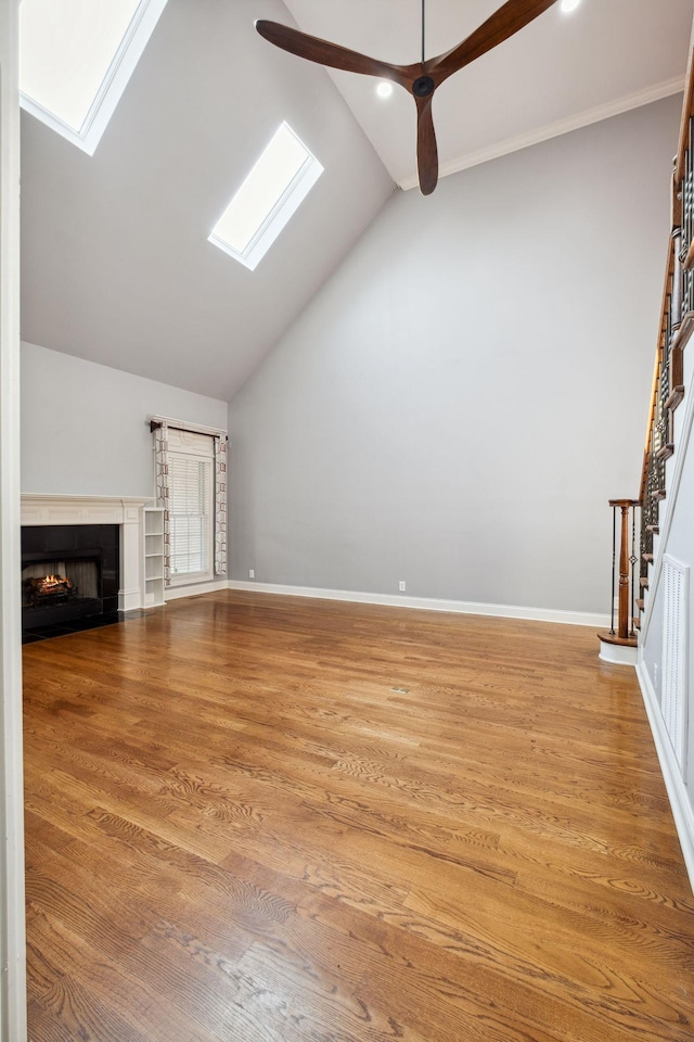 3334 Granite Springs Way, Murfreesboro, TN 37130 - unfurnished living room featuring a skylight, vaulted ceiling, a warm lit fireplace, stairs, and a ceiling fan