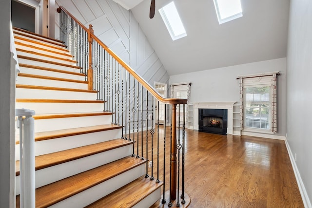3334 Granite Springs Way, Murfreesboro, TN 37130 - staircase featuring wood finished floors, a skylight, a tile fireplace, high vaulted ceiling, and baseboards