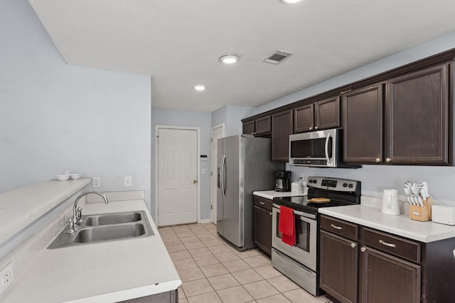 105 Patana Dr, White House, TN 37188 - kitchen with appliances with stainless steel finishes, a sink, dark brown cabinetry, light tile patterned floors, and light countertops