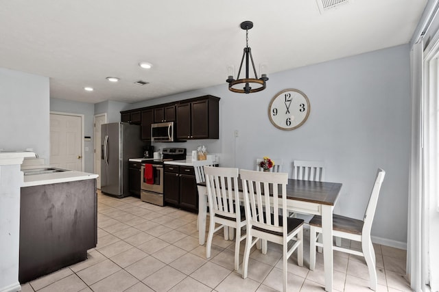 105 Patana Dr, White House, TN 37188 - kitchen with appliances with stainless steel finishes, light tile patterned floors, light countertops, a sink, and dark brown cabinetry