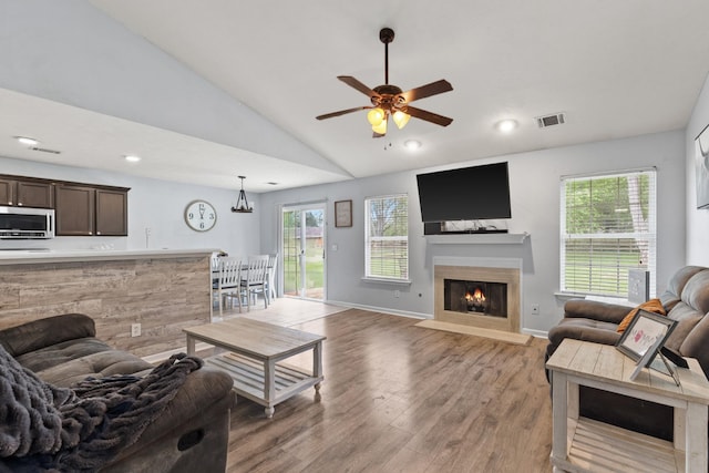 105 Patana Dr, White House, TN 37188 - living room with lofted ceiling, light wood finished floors, healthy amount of natural light, a ceiling fan, and a fireplace with flush hearth