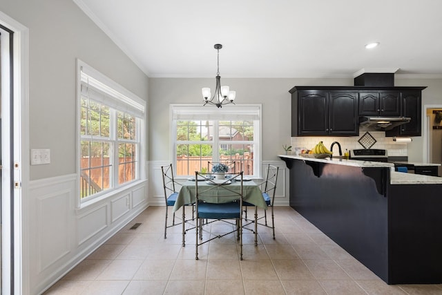 4702 Garcia Blvd, Murfreesboro, TN 37128 - dining room featuring a chandelier, light tile patterned flooring, ornamental molding, wainscoting, and a decorative wall