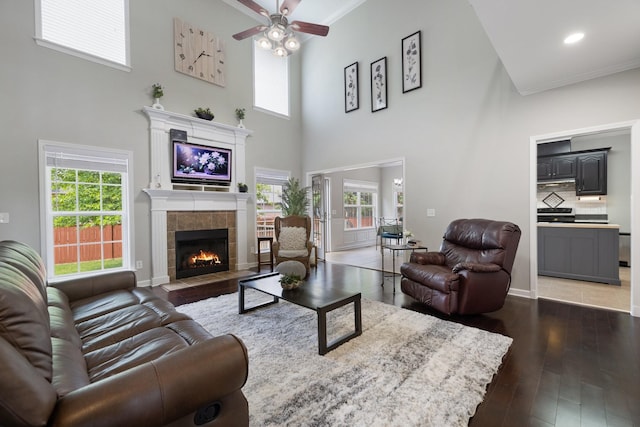 4702 Garcia Blvd, Murfreesboro, TN 37128 - living room featuring a tile fireplace, a high ceiling, a ceiling fan, hardwood / wood-style flooring, and ornamental molding