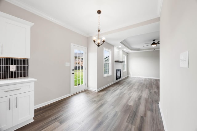 2586 Rafiki Dr, Clarksville, TN 37042 - unfurnished living room with ornamental molding, wood finished floors, a ceiling fan, a chandelier, and baseboards