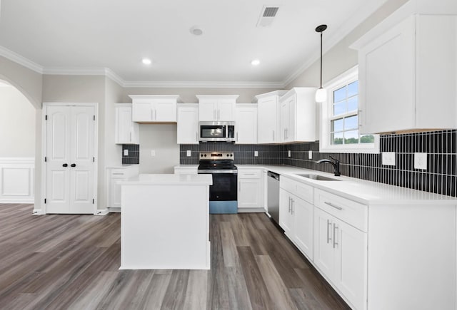 2586 Rafiki Dr, Clarksville, TN 37042 - kitchen featuring stainless steel appliances, a sink, a center island, white cabinetry, and crown molding