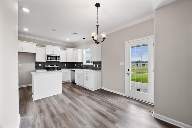 2586 Rafiki Dr, Clarksville, TN 37042 - kitchen featuring appliances with stainless steel finishes, a sink, ornamental molding, decorative backsplash, and a chandelier