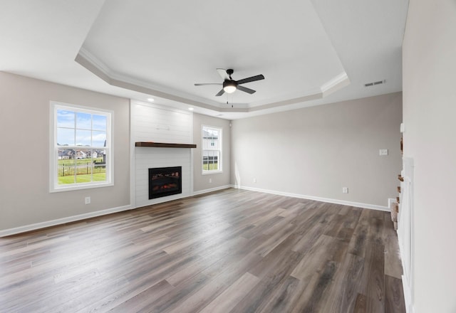 2586 Rafiki Dr, Clarksville, TN 37042 - unfurnished living room with a tray ceiling, a fireplace, a ceiling fan, dark wood-type flooring, and ornamental molding