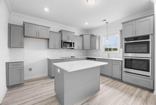 2582 Rafiki Dr, Clarksville, TN 37042 - kitchen with stainless steel appliances, gray cabinets, light countertops, backsplash, and ornamental molding