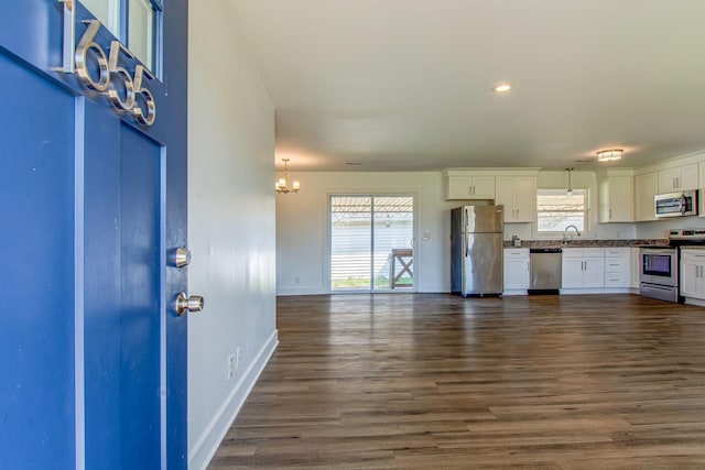 1655 Ben Johns Rd, Smyrna, TN 37167 - kitchen with stainless steel appliances, white cabinets, a chandelier, baseboards, and dark wood finished floors
