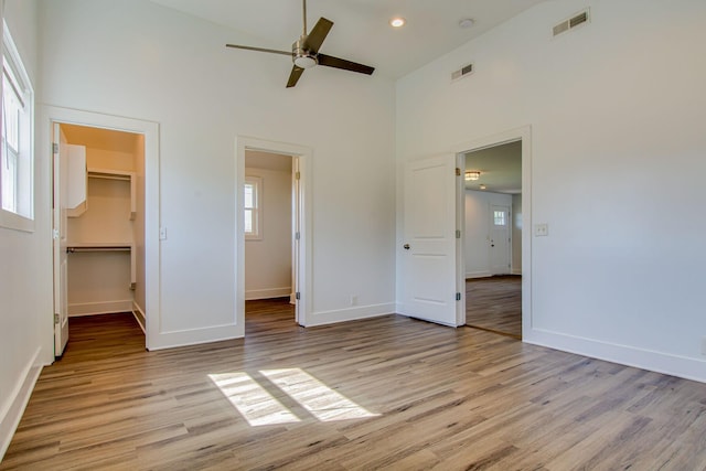 1655 Ben Johns Rd, Smyrna, TN 37167 - unfurnished bedroom featuring a towering ceiling, multiple windows, light wood-style floors, a spacious closet, and recessed lighting
