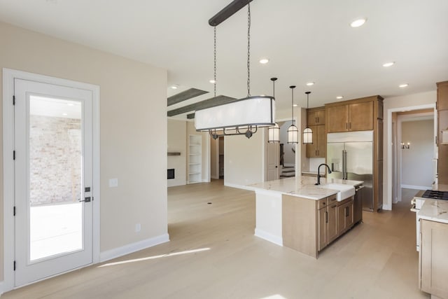 5962 Hunt Valley Dr, Spring Hill, TN 37174 - kitchen featuring light wood-style flooring, hanging light fixtures, brown cabinets, light stone counters, and recessed lighting