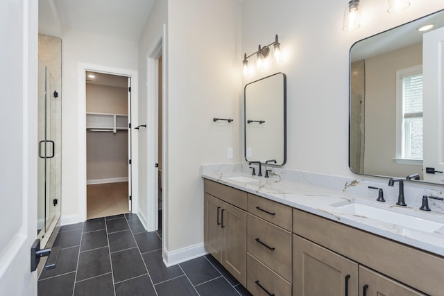 5962 Hunt Valley Dr, Spring Hill, TN 37174 - bathroom with a shower stall, double vanity, a walk in closet, tile patterned floors, and baseboards