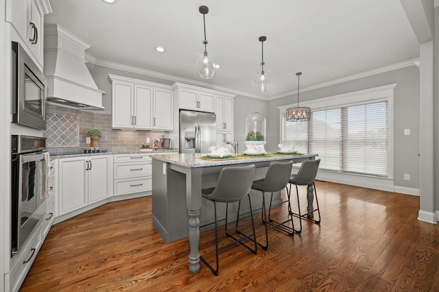 193 Knoxleigh Way, Murfreesboro, TN 37129 - kitchen with appliances with stainless steel finishes, wall chimney exhaust hood, a kitchen bar, decorative backsplash, and recessed lighting